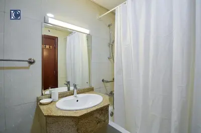 a bathroom with a sink and a white shower curtain at Cozy 1-Bedroom Apartment in N2 Lakepoint Tower JLT in Dubai