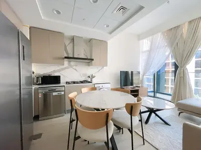 a kitchen with a table and chairs in a room at Brand New Spacious 3-BedroomIAzizi Riviera 16 in Dubai