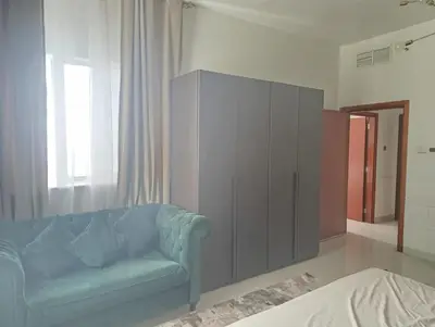 a living room with a blue couch and a cabinet at In the heart of Dubai in Dubai