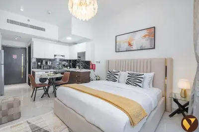 a bedroom with a large bed and a kitchen at Vogue Arjan Jwelz by Danube near Miracle and Butterfly Garden, Studio Apartment with Balcony and Vibrant Community View, Access to all Amenities in Dubai