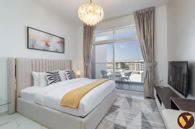 a bedroom with a large bed and a large window at Vogue Arjan Jwelz by Danube near Miracle and Butterfly Garden, Studio Apartment with Balcony and Vibrant Community View, Access to all Amenities in Dubai