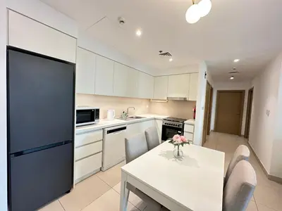a kitchen with a table with a vase of flowers on it at Coastal Charm - Fully Furnished 2-Bedroom Apartment with Spectacular Views by Petals Holiday Homes in Dubai