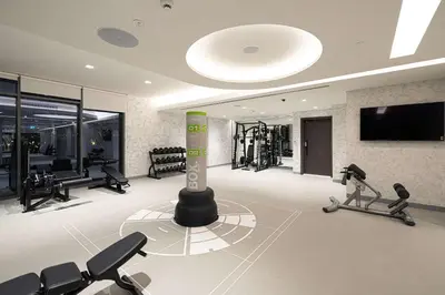 a gym with exercise bikes and a tv in a room at Seaside Serenity 1Bd Beachfront Apartment in Dubai