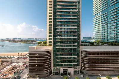 two tall buildings next to a beach and the ocean at Seaside Serenity 1Bd Beachfront Apartment in Dubai