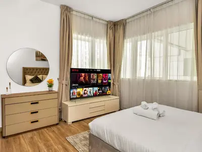 a bedroom with a bed and a flat screen tv at Spacious 3BR High Floor Palm View in Dubai Marina in Dubai