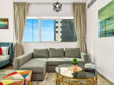 a living room with a couch and a table at Spacious 3BR High Floor Palm View in Dubai Marina in Dubai