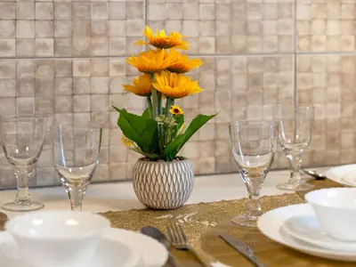 a vase of flowers sitting on a table with glasses at Spacious 3BR High Floor Palm View in Dubai Marina in Dubai