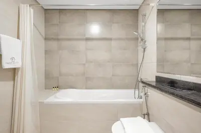 a bathroom with a bath tub and a toilet at Elegant 2BR with Balcony and Burj Khalifa Skyline Views in Dubai