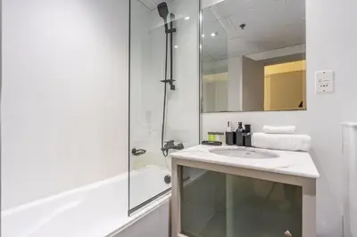 a white bathroom with a sink and a shower at HAVN - 2 Bedroom in Marina Quays, Dubai Marina in Dubai