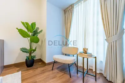 a room with a chair and a table and a plant at Revamped 1BR Unit with Partial Sea & Palm Jumeirah Views Close to Beach , Elite Residence, Dubai Marina by Deluxe Holiday Homes in Dubai