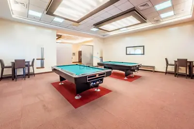 a room with two pool tables and chairs at Revamped 1BR Unit with Partial Sea & Palm Jumeirah Views Close to Beach , Elite Residence, Dubai Marina by Deluxe Holiday Homes in Dubai