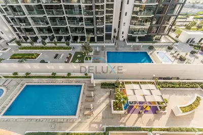 an overhead view of two swimming pools in a building at Pool Views 1BR Close to Major Landmarks in Azizi Riviera 18, Al Merkadh by Deluxe Holiday Homes in Dubai