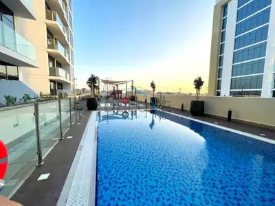 a swimming pool on the roof of a building at Pool Views 1BR Close to Major Landmarks in Azizi Riviera 18, Al Merkadh by Deluxe Holiday Homes in Dubai
