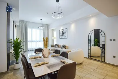 a living room with a table and chairs and a couch at Exclusive 2BR Home Marina Residence 4, The Palm in Dubai