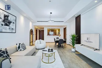 a living room with a white couch and a table at Exclusive 2BR Home Marina Residence 4, The Palm in Dubai