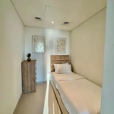 a small bedroom with a bed and two pictures on the wall at THE COVE Creek Harbour in Dubai