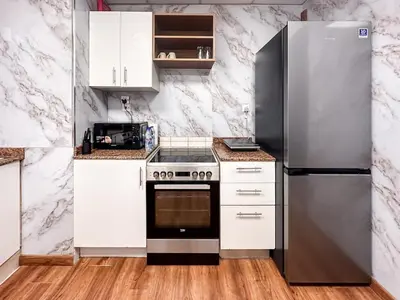 a kitchen with white cabinets and a stainless steel refrigerator at Spacious High Floor Apartment Dubai Marina in Dubai