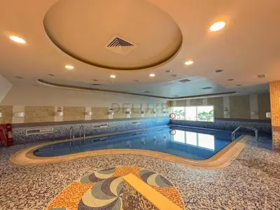 a swimming pool in a large building with a swimming pool at Upgraded 1BR Overlooking Palm Jumeirah & Sea Views from Living to Bedroom, Elite Residence, Dubai Marina by Deluxe Holiday Homes in Dubai