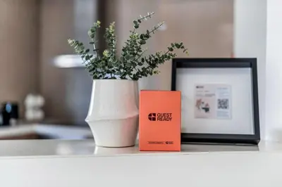 a vase with a plant in it next to a book at GuestReady - Luxurious interiors in Business Bay in Dubai