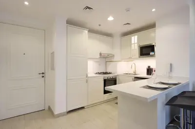 a kitchen with white cabinets and a white counter top at Livbnb-Modern 1BR Oasis with Stunning Terrace, JVC in Dubai
