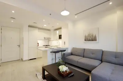 a living room with a couch and a table at Livbnb-Modern 1BR Oasis with Stunning Terrace, JVC in Dubai