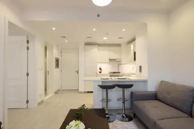a living room with a couch and a kitchen at Livbnb-Modern 1BR Oasis with Stunning Terrace, JVC in Dubai
