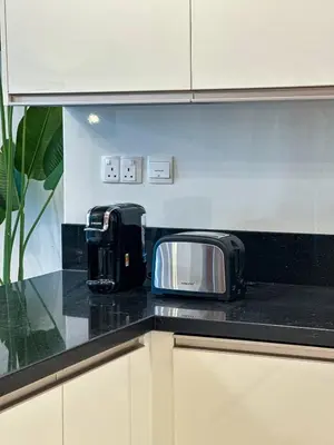 a black counter top with a toaster and a toaster oven at Luxury Meets Serenity 2BR Apt in Noura Tower in Dubai