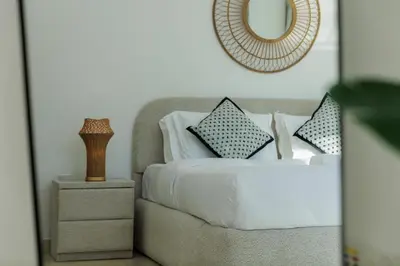 a bedroom with a bed with pillows and a mirror at Waterfront flat Stunning view Sleeps 6 in Dubai