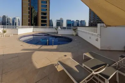 a patio with chairs and a swimming pool on a building at Waterfront flat Stunning view Sleeps 6 in Dubai