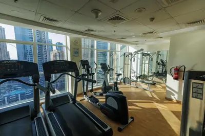 a gym with treadmills and ellipticals in a building at Waterfront flat Stunning view Sleeps 6 in Dubai