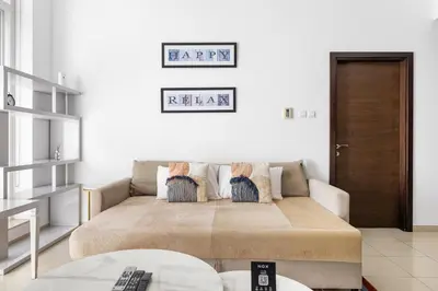 a living room with a couch with pillows on it at 1BR Botanica Dubai Marina in Dubai