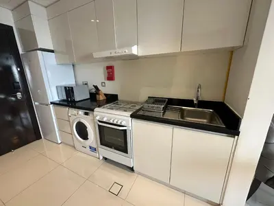 a kitchen with a sink and a stove and a dishwasher at Stunning Studio at JVC Damac Ghalia - Msgetaways in Dubai