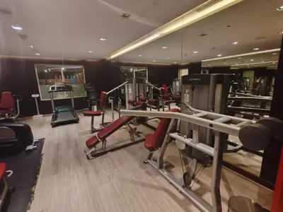 a gym with a lot of exercise equipment and mirrors at Stunning Studio at JVC Damac Ghalia - Msgetaways in Dubai