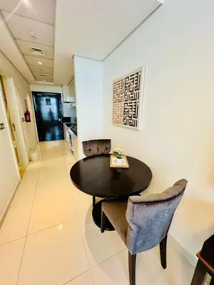 a dining room with a black table and chairs at Stunning Studio at JVC Damac Ghalia - Msgetaways in Dubai