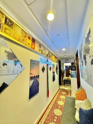 a hallway with posters on the wall and a couch at Bed in mixed room in Dubai