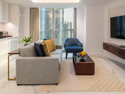 a living room with a couch and a tv at Cheval Maison - Expo City Dubai in Dubai