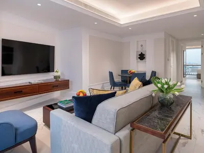 a living room with a couch and a tv at Cheval Maison - Expo City Dubai in Dubai