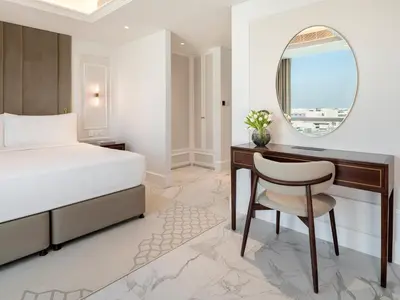 a bedroom with a bed and a desk and a mirror at Cheval Maison - Expo City Dubai in Dubai