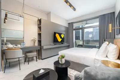 a bedroom with a king sized bed and a desk at Vogue Downtown Mag 318 near Burj Khalifa and Dubai Mall, Studio Apartment with Balcony, Canal and City View, Access to all Amenities in Dubai