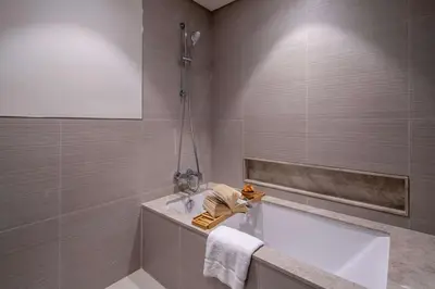 a bathroom with a bath tub and a sink at Frank Porter - Grande Signature Residences in Dubai