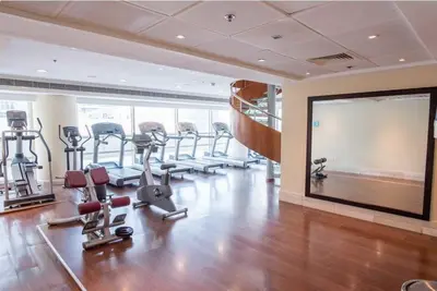 a gym with treadmills and machines in a room at Cozy 1bd near JBR Beach in Dubai