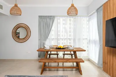 a dining room with a wooden table and a window at Cozy 1bd near JBR Beach in Dubai