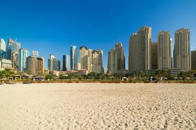 a city skyline with a sandy beach in front of a city at Cozy 1bd near JBR Beach in Dubai