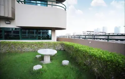 a white table in the grass in front of a building at Destination Partition Room in Tecom Near Metro in Dubai