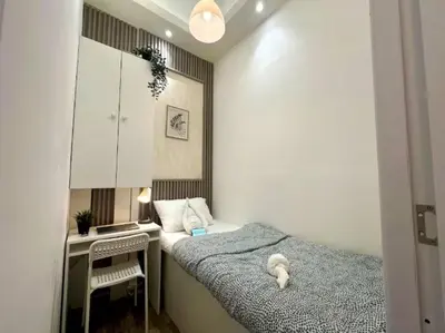 a small bedroom with a bed and a desk at Elegance Partition Room in Tecom Near ICM Metro in Dubai