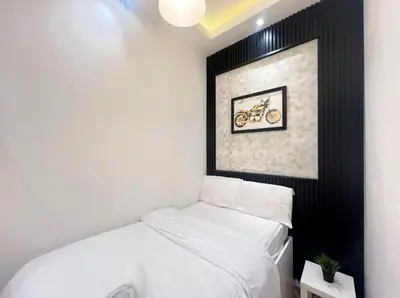 a small room with a bed and a picture of a motorcycle at Attraction Partition Room in Barsha heights Tecom in Dubai