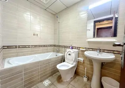 a bathroom with a tub and a toilet and a sink at Attraction Partition Room in Barsha heights Tecom in Dubai