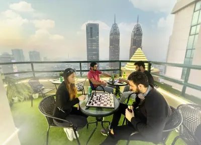 a group of people playing chess on the roof of a building at Network Partition Room Near Internet City Metro in Dubai