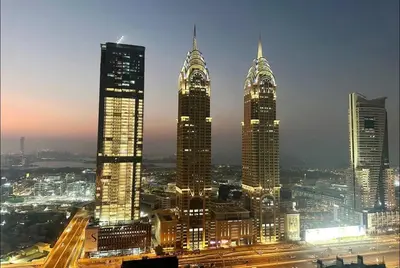 a group of tall buildings in a city at night at Network Partition Room Near Internet City Metro in Dubai