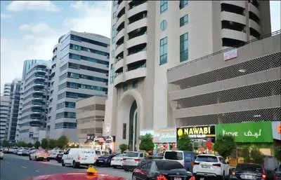 a busy city street with cars parked in front of a building at Network Partition Room Near Internet City Metro in Dubai